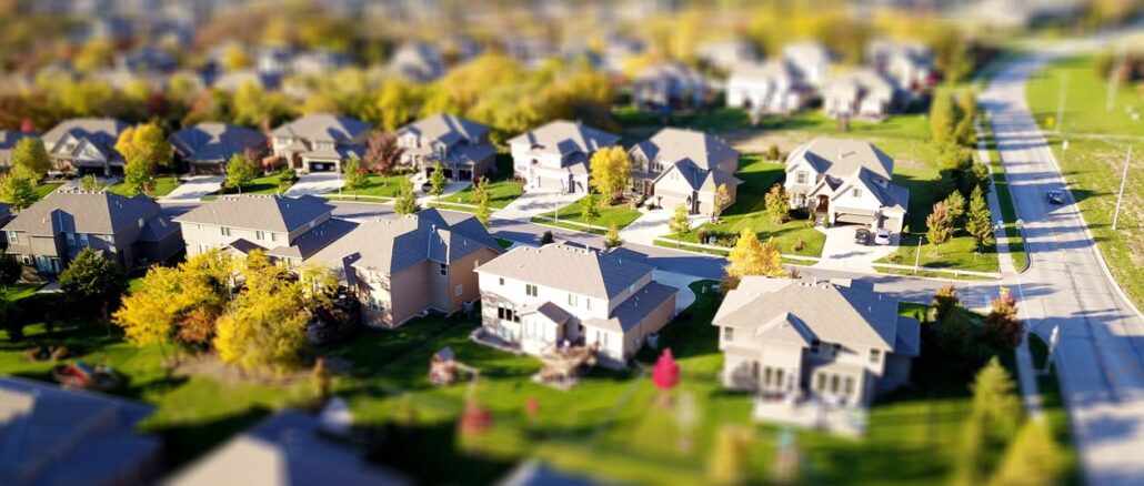 Bright, sunny view of a residential neighborhood in Castle Rock, Colorado, with modern homes in the foreground, representi...