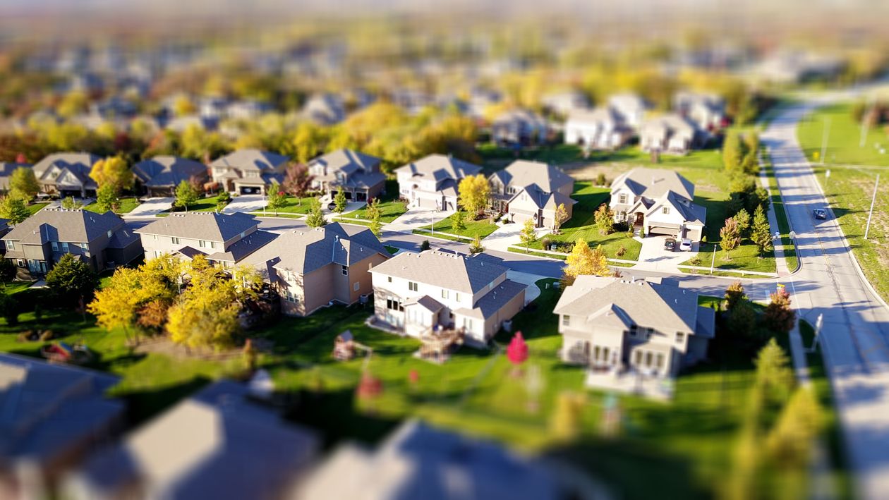 Bright, sunny view of a residential neighborhood in Castle Rock, Colorado, with modern homes in the foreground, representi...