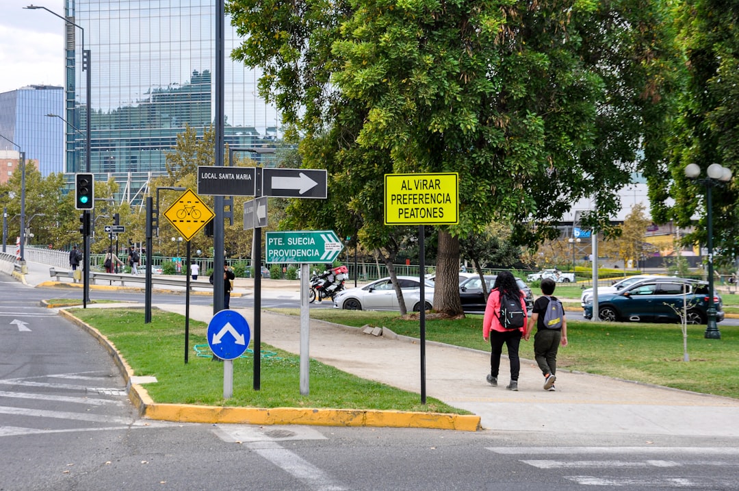 Professionally dressed person stands at a fork in a path, contemplating which direction to take, symbolizing the choice be...